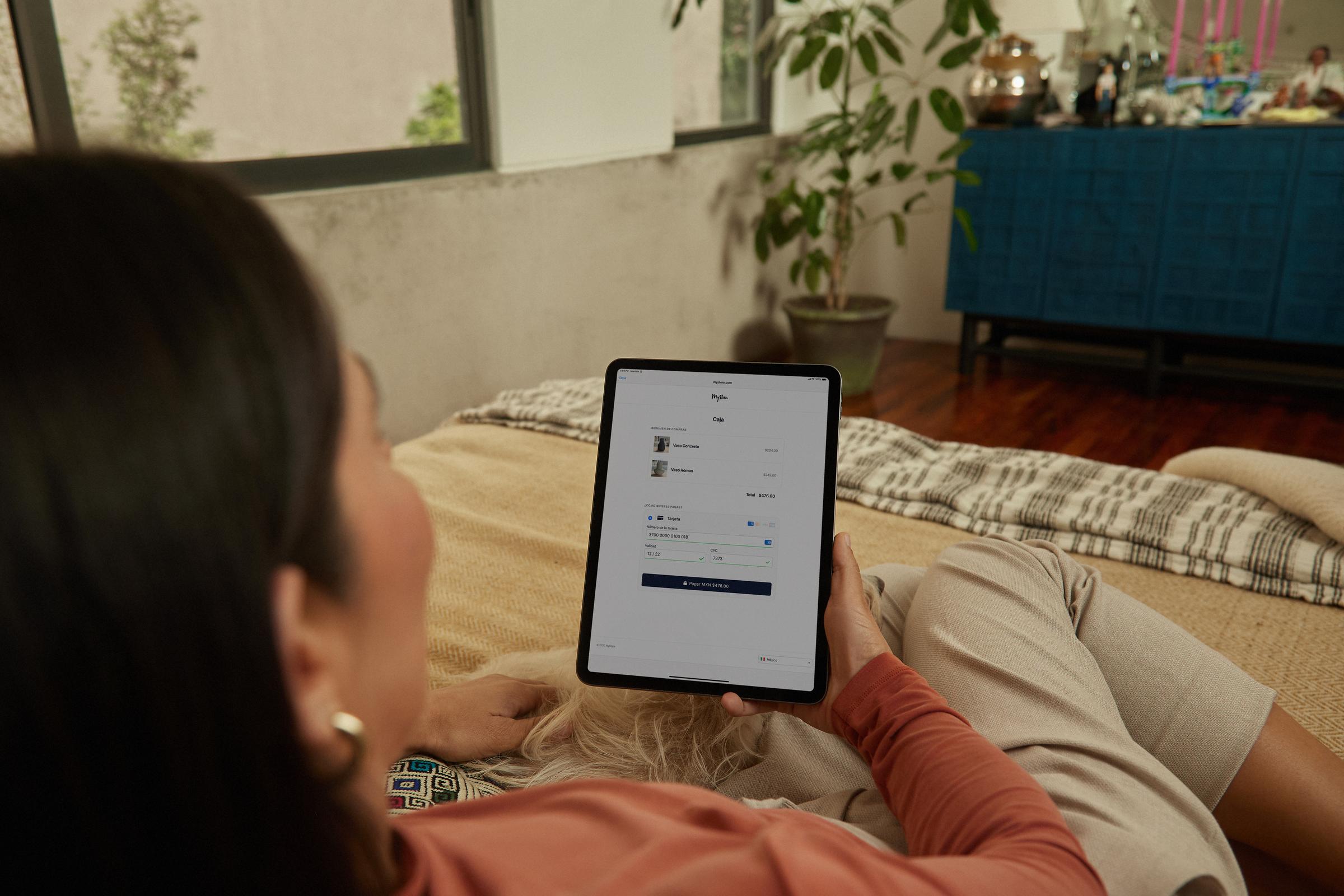 Persona che si sdraia con un tablet che mostra l'interfaccia di pagamento Adyen
