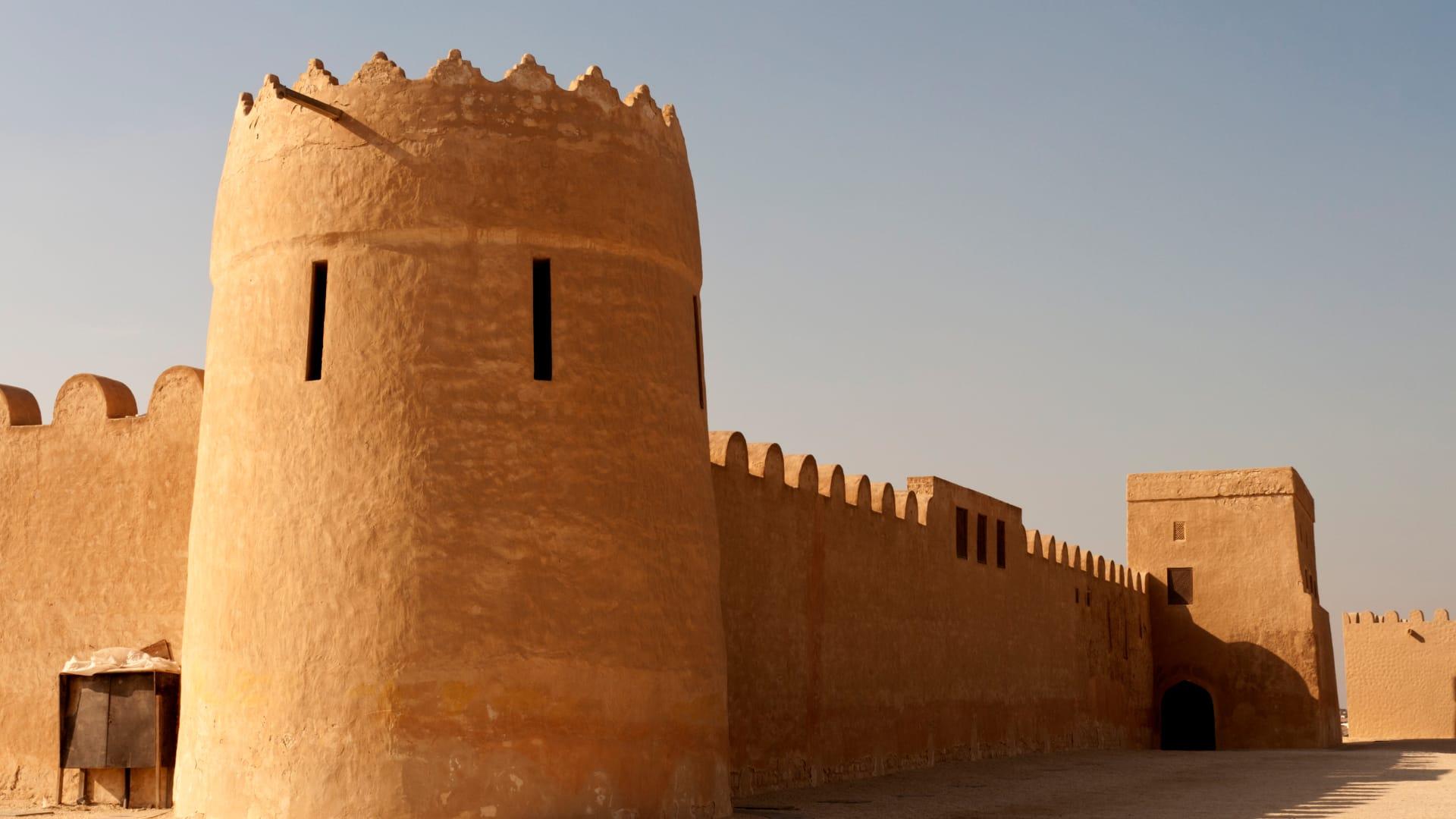 Vista soleggiata di una fortezza di terra tradizionale con torri merlate e mura in Bahrain