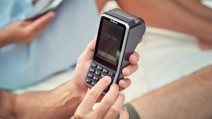 Close-up of a person's hands using an Adyen payment terminal