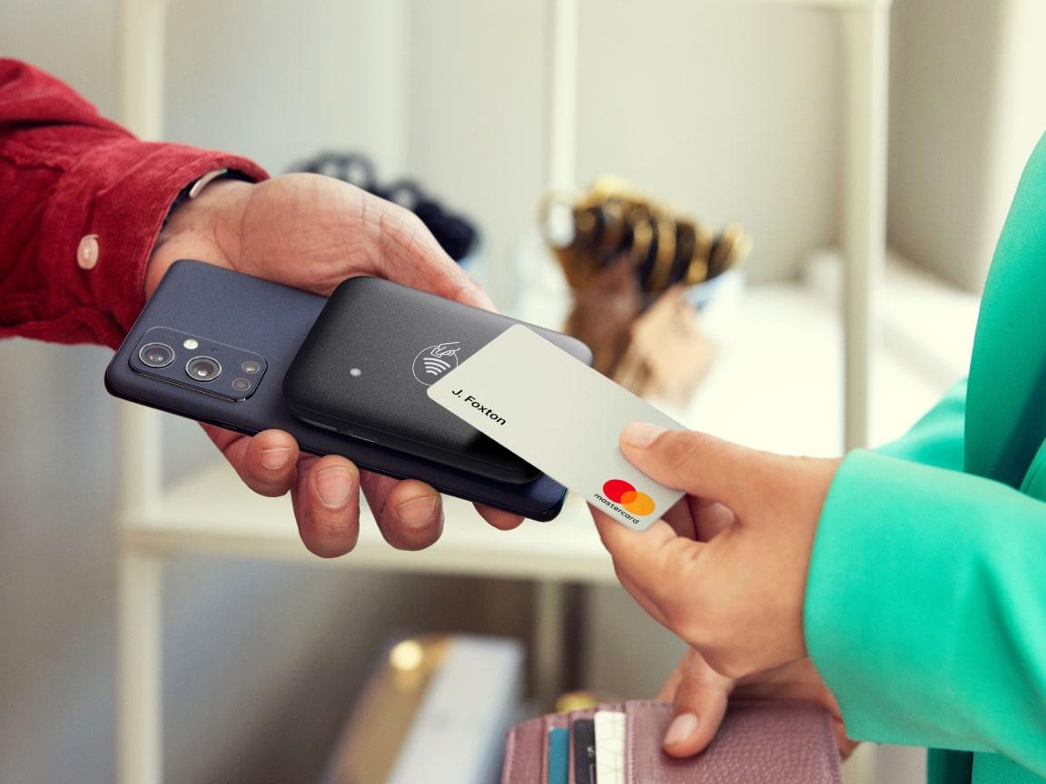 Personne utilisant un smartphone pour accepter un paiement sans contact d'une carte de crédit.